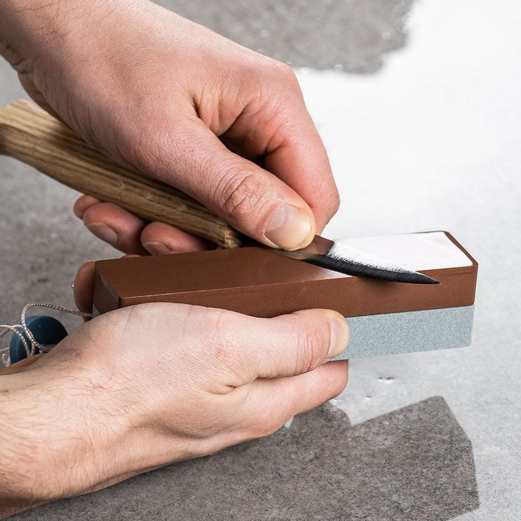 Person sharpening a blade on a King K40 Japanese combo whetstone.