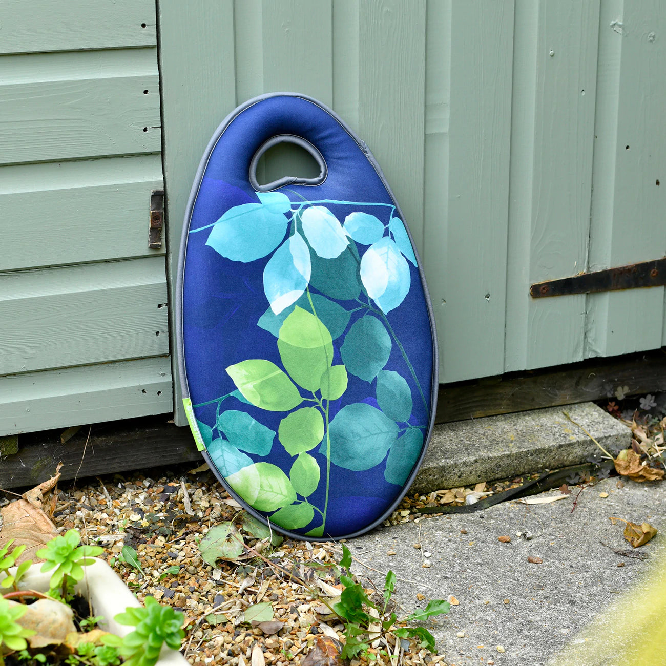 Garden kneeler leaning against shed.