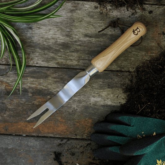 Dandelion weeding tool on potting bench.