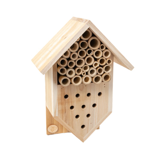A wooden insect hotel with bamboo tubes for nesting, designed for ladybirds and other beneficial insects.