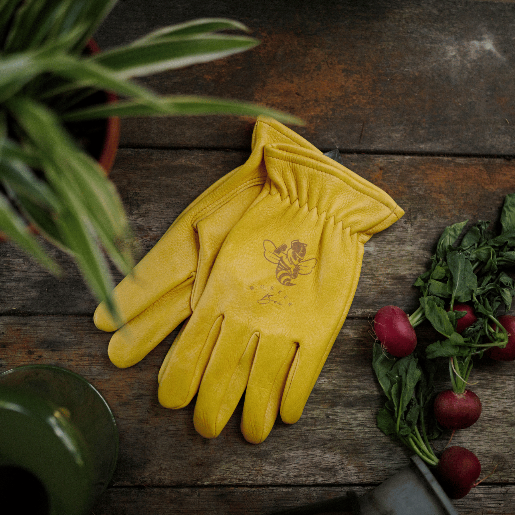 Keepers Worker Bee gardening gloves on potting bench.