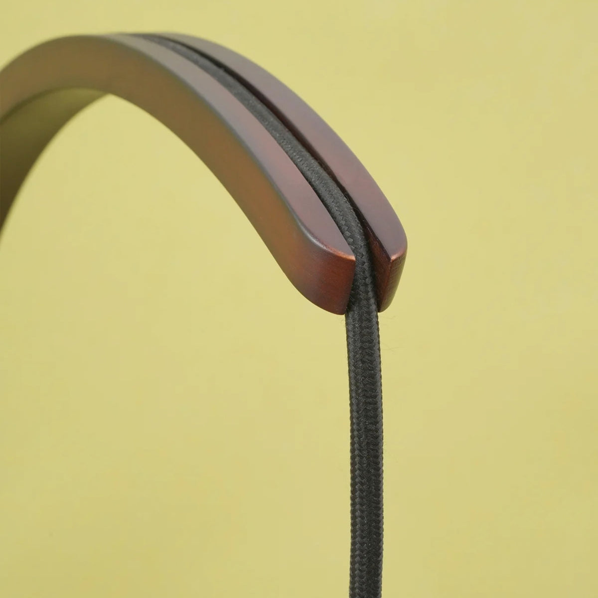 Close-up of Soltech Luna dark timber curved wall mount bracket showing hardwood grain and cord routing.