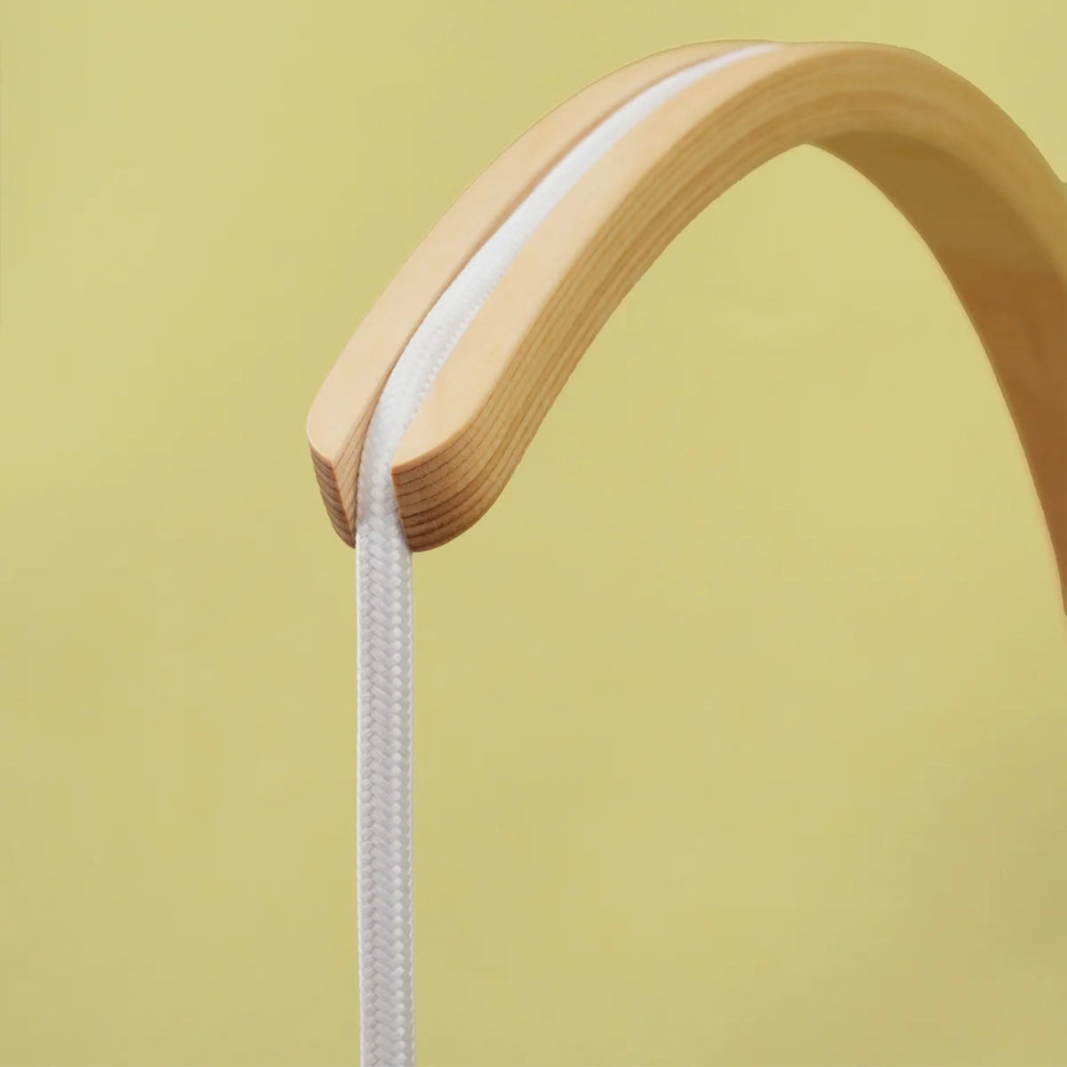 Close-up of Soltech Luna natural timber curved wall mount bracket showing hardwood grain and cord routing.